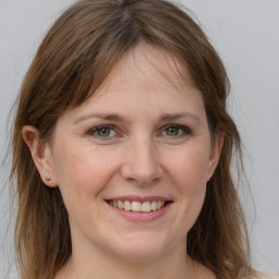 Joyful white young-adult female with long  brown hair and grey eyes