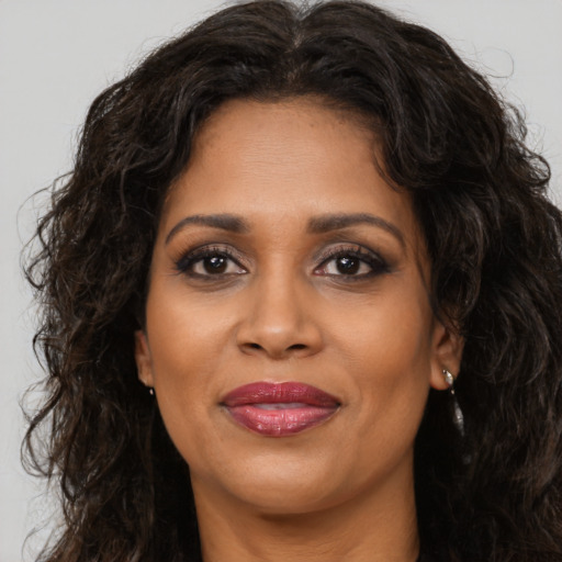 Joyful latino adult female with long  brown hair and brown eyes