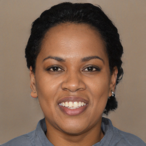 Joyful black young-adult female with short  black hair and brown eyes