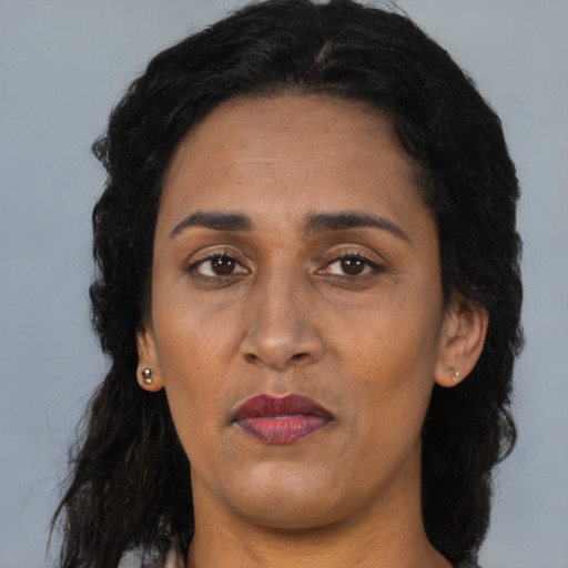 Joyful black adult female with long  black hair and brown eyes