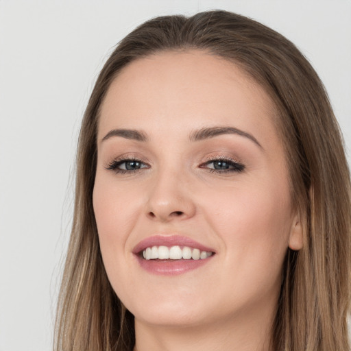 Joyful white young-adult female with long  brown hair and grey eyes