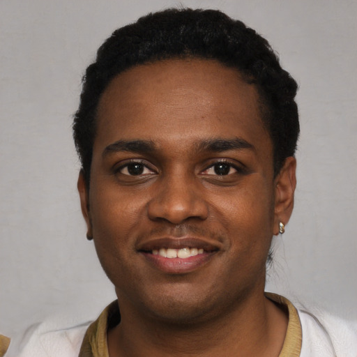 Joyful black young-adult male with short  black hair and brown eyes
