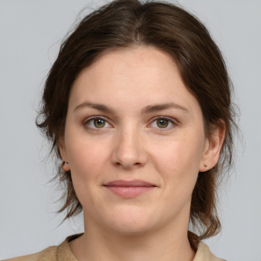 Joyful white young-adult female with medium  brown hair and green eyes