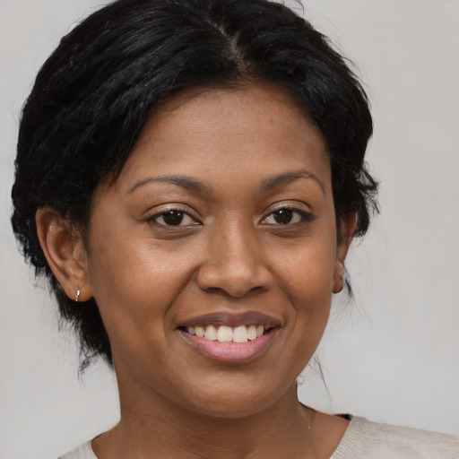 Joyful black young-adult female with medium  brown hair and brown eyes