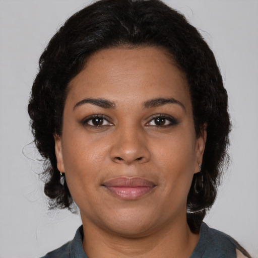 Joyful black young-adult female with medium  brown hair and brown eyes