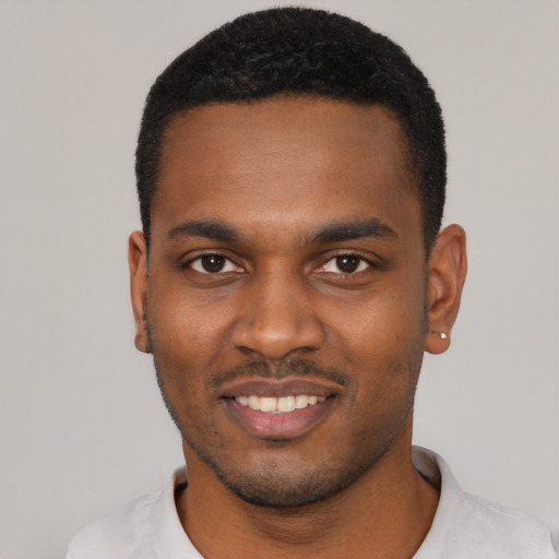 Joyful black young-adult male with short  black hair and brown eyes