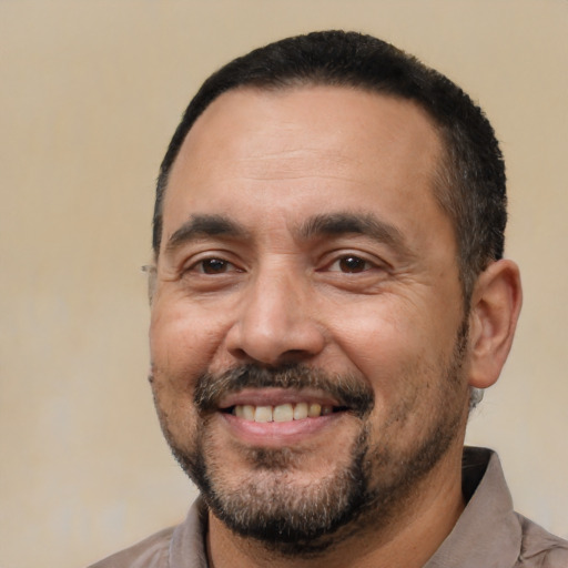 Joyful white adult male with short  black hair and brown eyes