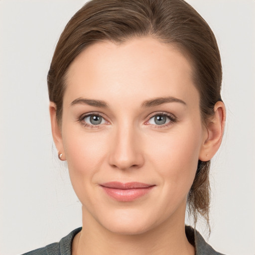 Joyful white young-adult female with medium  brown hair and grey eyes