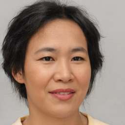 Joyful asian adult female with medium  brown hair and brown eyes