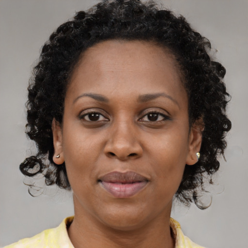 Joyful black adult female with short  brown hair and brown eyes
