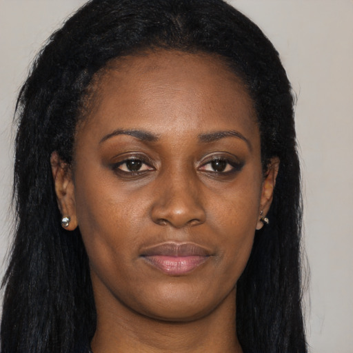 Joyful black young-adult female with long  black hair and brown eyes