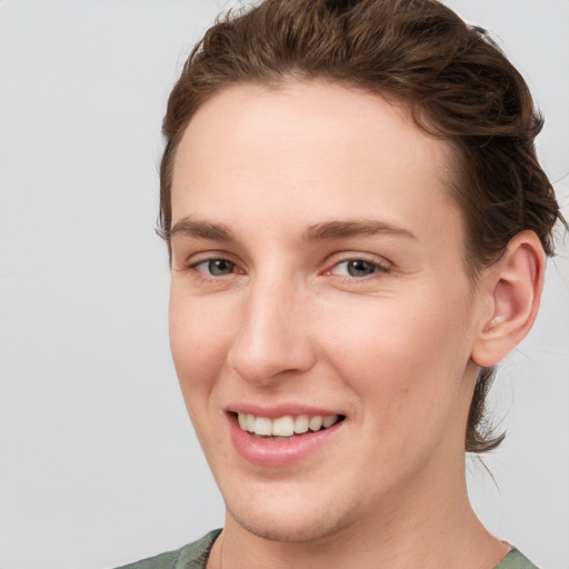 Joyful white young-adult female with short  brown hair and grey eyes