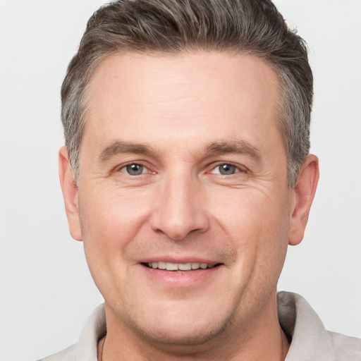 Joyful white adult male with short  brown hair and brown eyes