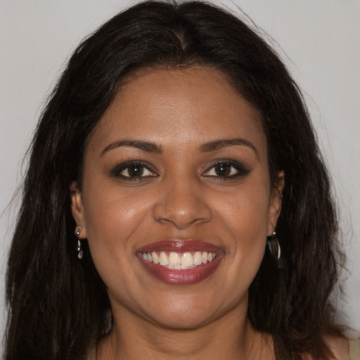 Joyful black young-adult female with long  brown hair and brown eyes