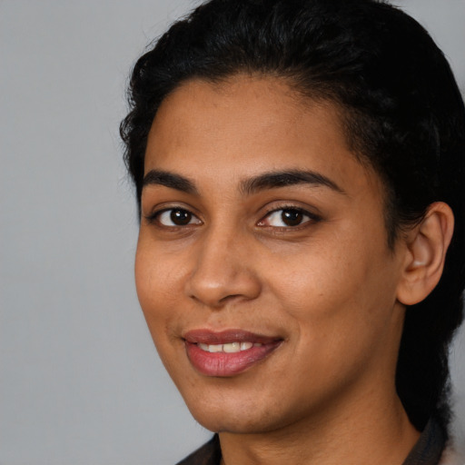 Joyful latino young-adult female with short  black hair and brown eyes