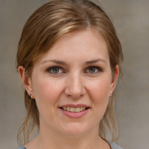 Joyful white young-adult female with medium  brown hair and grey eyes