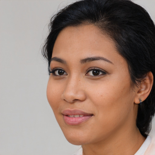 Joyful latino young-adult female with medium  brown hair and brown eyes