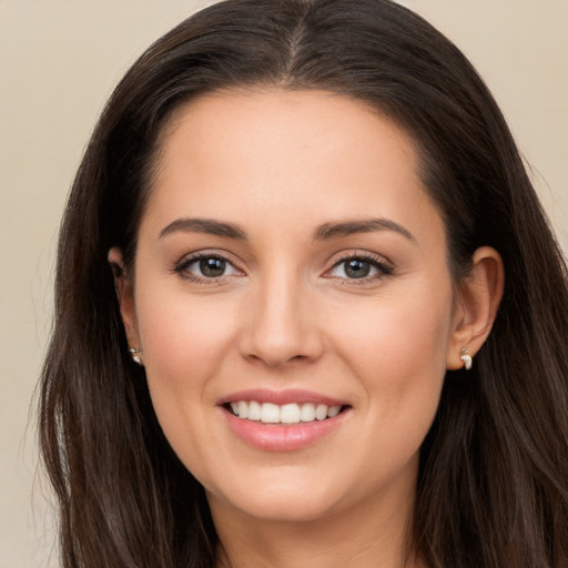 Joyful white young-adult female with long  brown hair and brown eyes