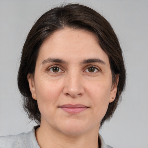 Joyful white adult female with medium  brown hair and brown eyes