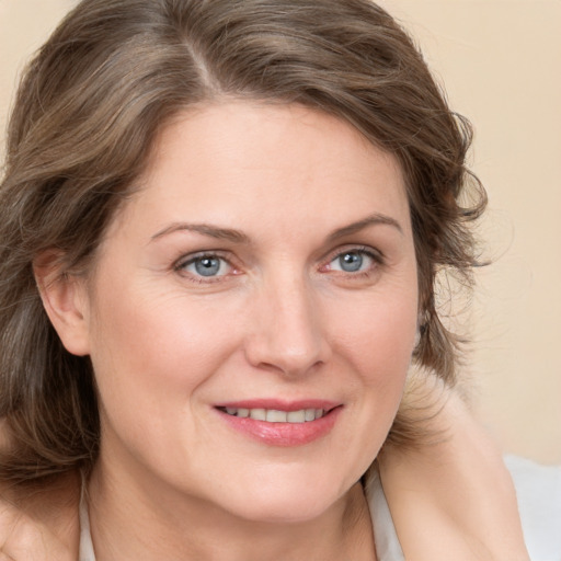 Joyful white adult female with medium  brown hair and brown eyes