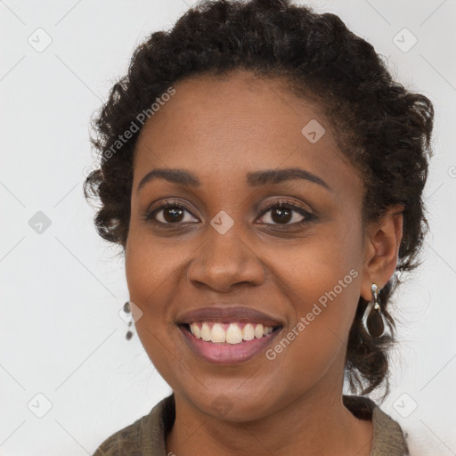 Joyful black young-adult female with long  brown hair and brown eyes