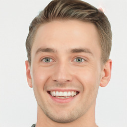 Joyful white young-adult male with short  brown hair and grey eyes