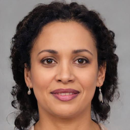Joyful latino adult female with medium  brown hair and brown eyes