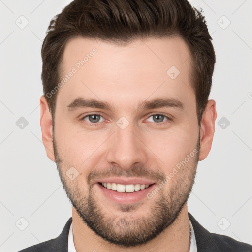 Joyful white young-adult male with short  brown hair and grey eyes