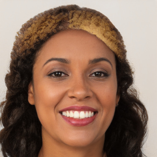 Joyful black young-adult female with long  brown hair and brown eyes