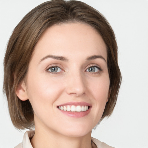 Joyful white young-adult female with medium  brown hair and green eyes