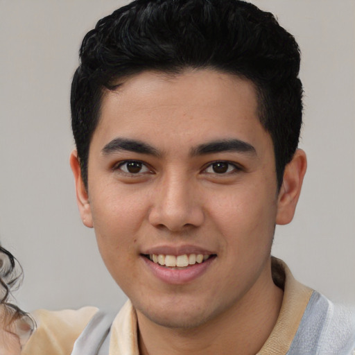 Joyful latino young-adult male with short  black hair and brown eyes