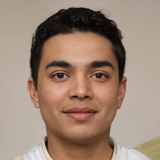 Joyful latino young-adult male with short  black hair and brown eyes