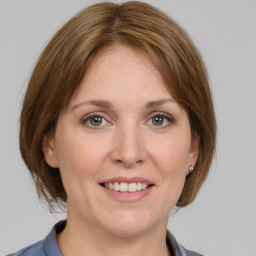 Joyful white adult female with medium  brown hair and grey eyes