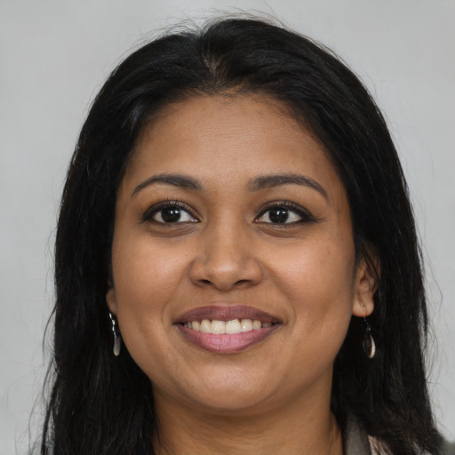 Joyful black young-adult female with long  brown hair and brown eyes