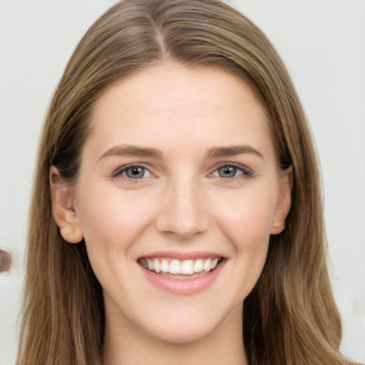 Joyful white young-adult female with long  brown hair and grey eyes