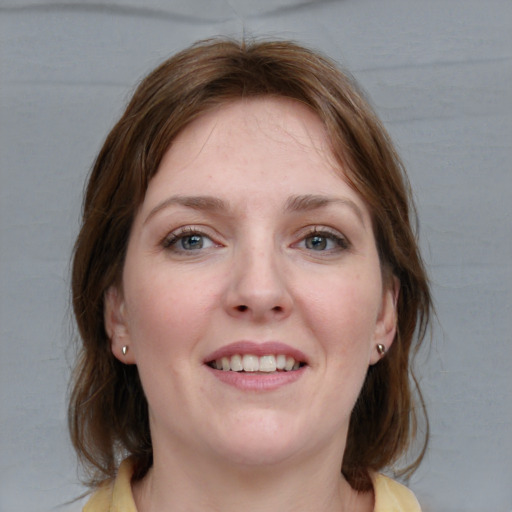 Joyful white young-adult female with medium  brown hair and blue eyes