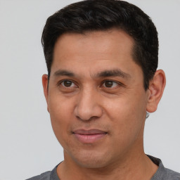 Joyful white adult male with short  black hair and brown eyes
