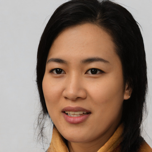 Joyful asian young-adult female with long  brown hair and brown eyes