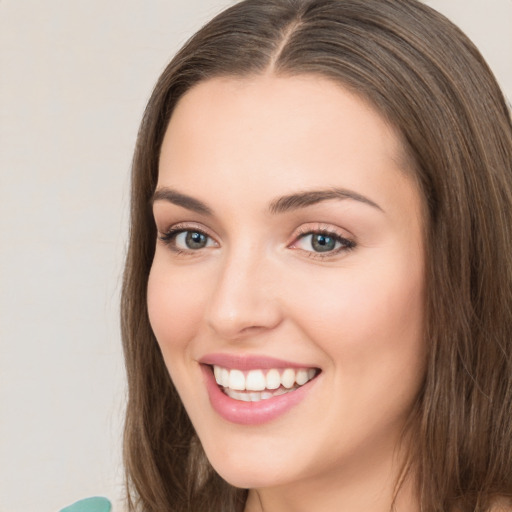 Joyful white young-adult female with long  brown hair and green eyes