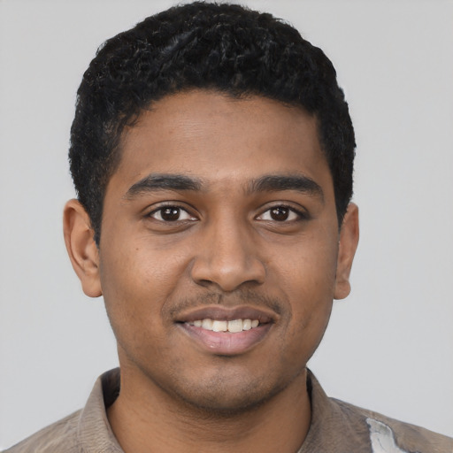Joyful black young-adult male with short  brown hair and brown eyes