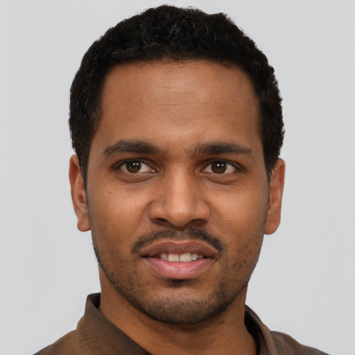 Joyful black young-adult male with short  black hair and brown eyes