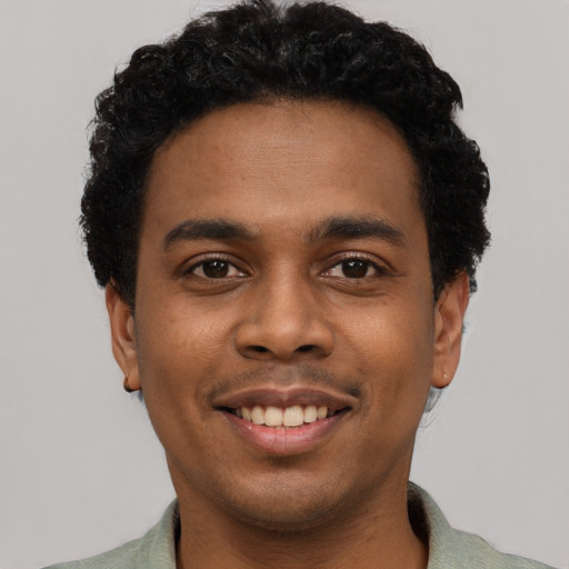 Joyful black young-adult male with short  black hair and brown eyes