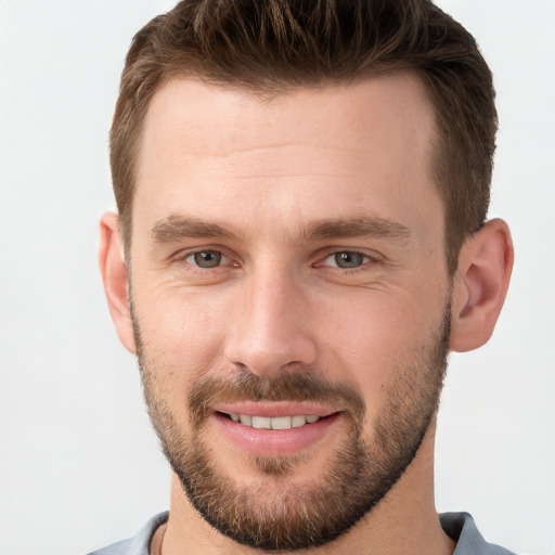 Joyful white young-adult male with short  brown hair and grey eyes