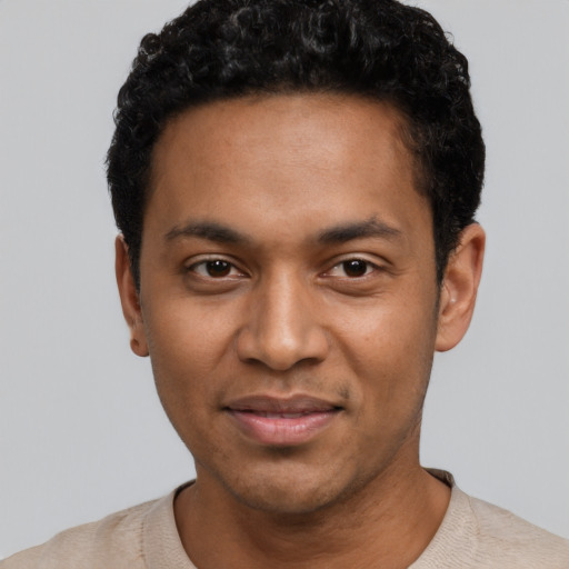 Joyful black young-adult male with short  black hair and brown eyes