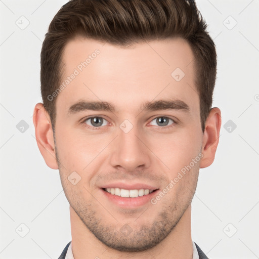 Joyful white young-adult male with short  brown hair and grey eyes