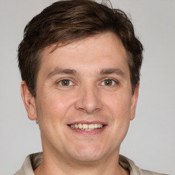 Joyful white young-adult male with short  brown hair and grey eyes