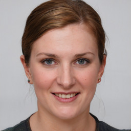 Joyful white young-adult female with medium  brown hair and blue eyes