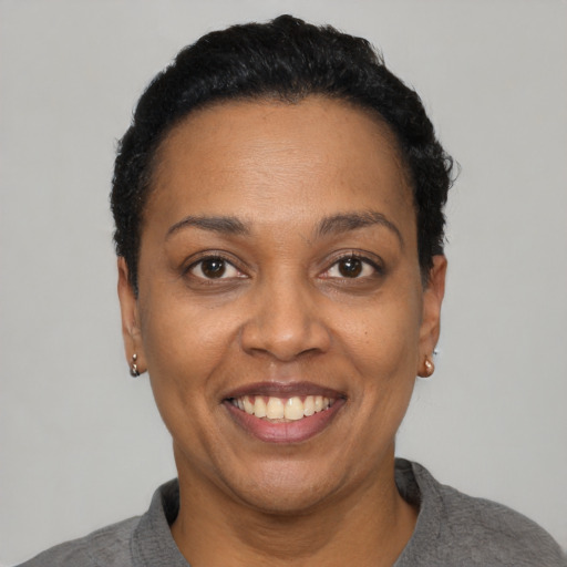 Joyful black adult female with short  black hair and brown eyes