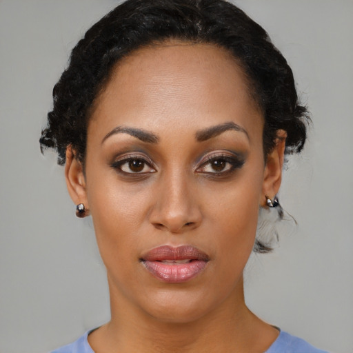 Joyful black young-adult female with short  black hair and brown eyes