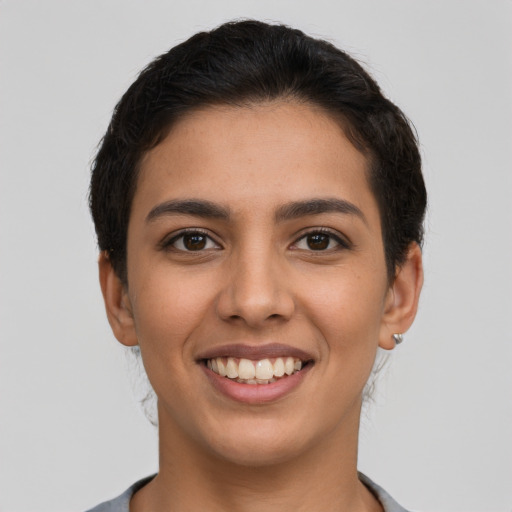 Joyful latino young-adult female with short  brown hair and brown eyes